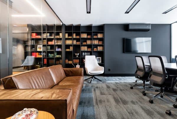 Imagem de um ambiente moderno de escritório, com uma mesa de reuniões elegante e prateleiras repletas de livros, transmitindo um espaço sofisticado e profissional para a sede de uma empresa.