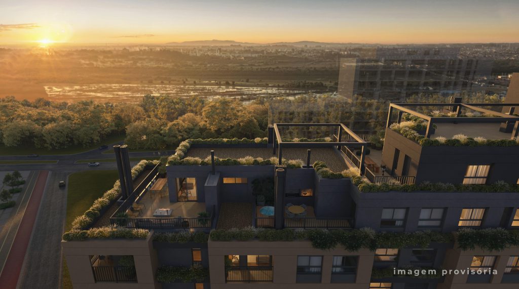 Vista aérea ao pôr do sol de cobertura de edifício com varandas e vegetação, cercada por área verde e ruas.