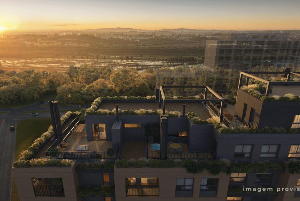 Vista aérea ao pôr do sol de cobertura de edifício com varandas e vegetação, cercada por área verde e ruas.